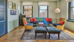 A living room with a sofa, two armchairs, a coffee table, and a rug. - Hotel Per La (Los Angeles)