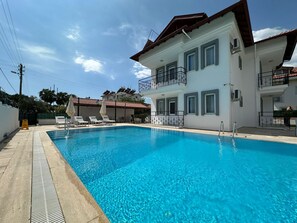 A swimming pool with lounge chairs and a two-story building with balconies. - Stay Dalyan Apart Hotel (Ortaca)