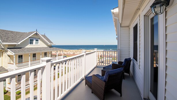 A balcony with wicker furniture and a view of the ocean. - Shawmont Hotel  (Ocean Grove)