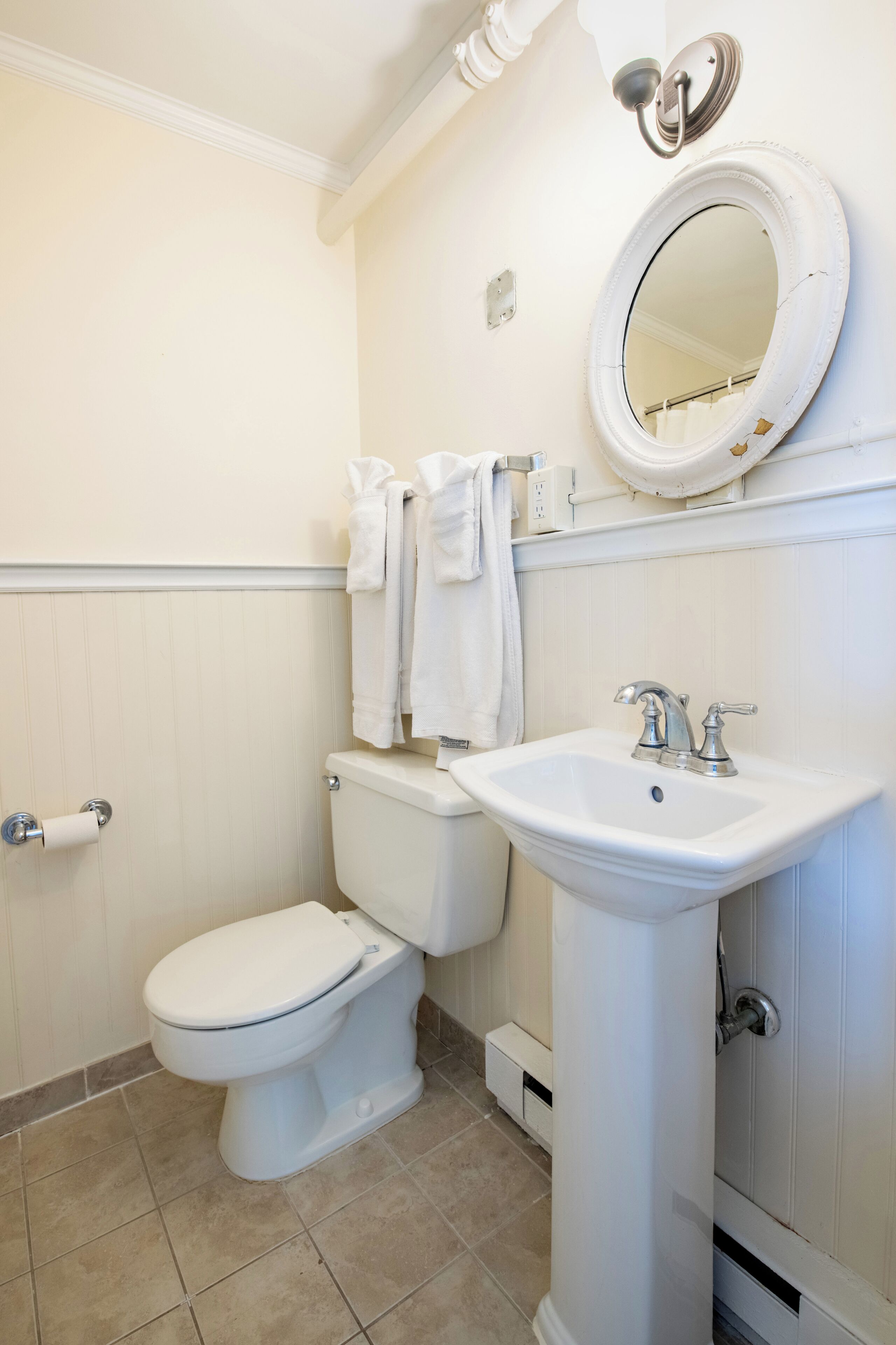 Un baño con inodoro, lavabo y espejo.