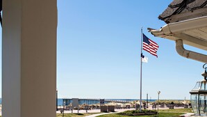 A coastal view with a flag, a pier, and a clear sky. - Shawmont Hotel  (Ocean Grove)