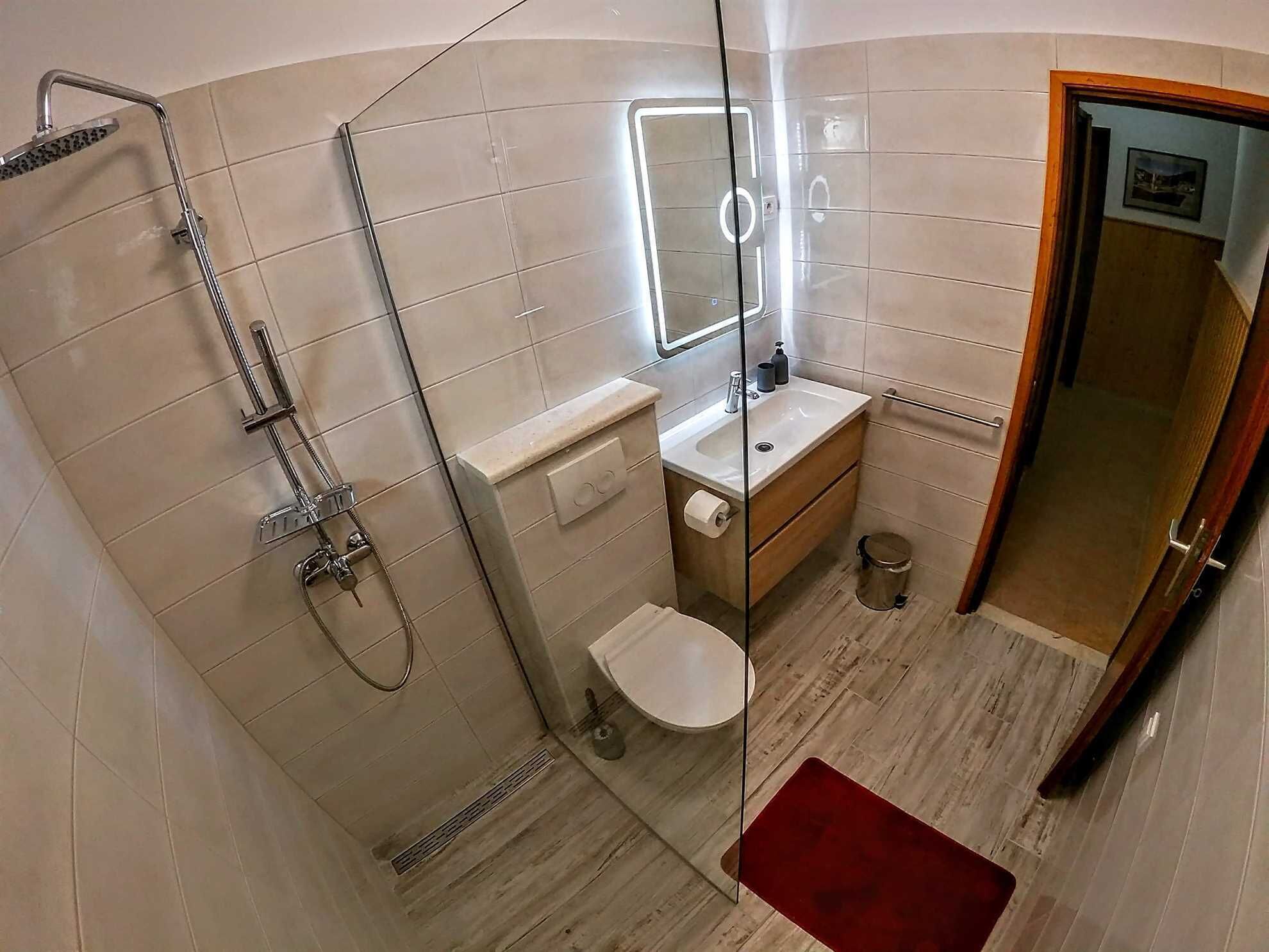 Une petite salle de bain comprenant une douche, des toilettes et un lavabo.