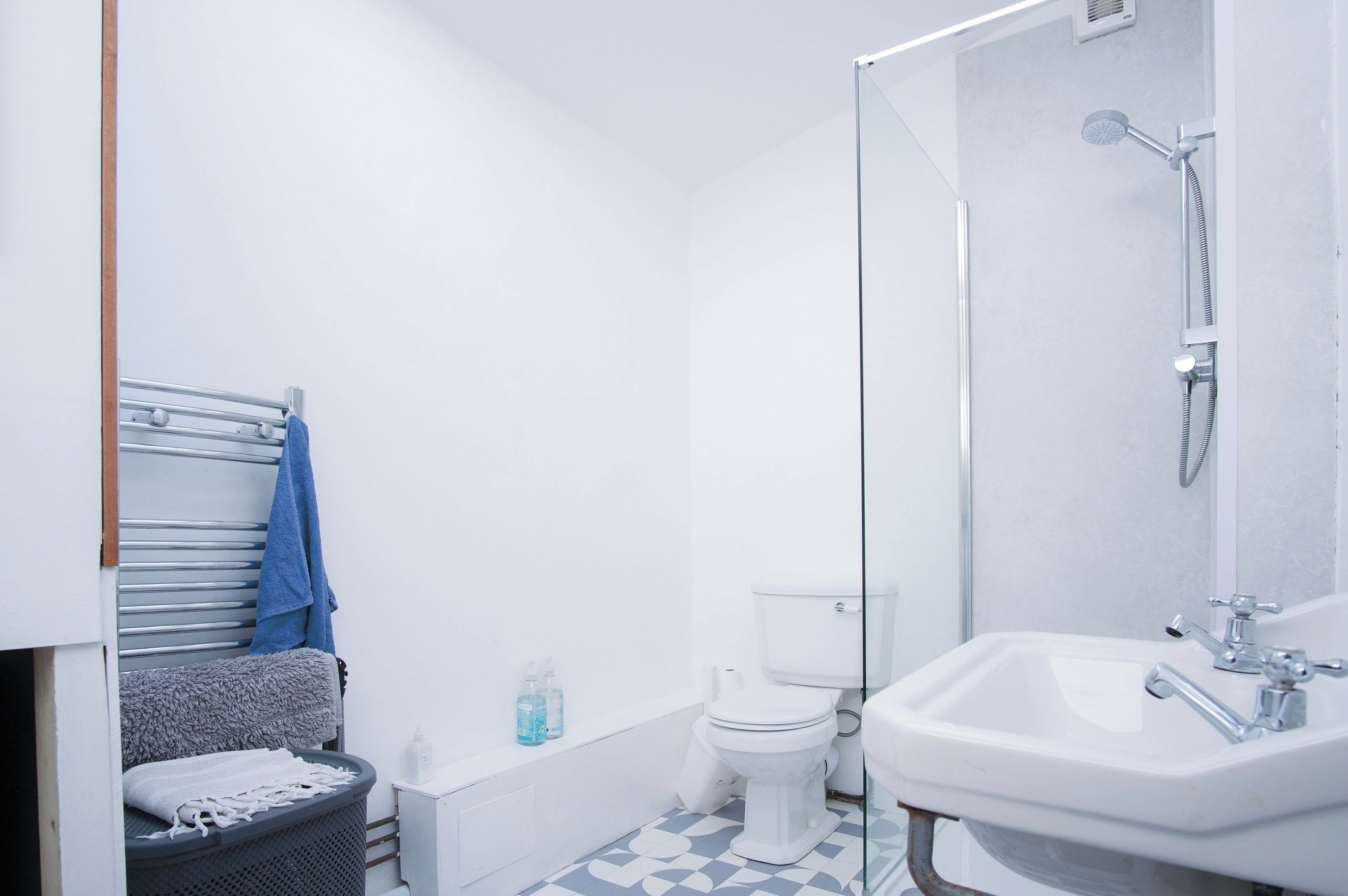 A bathroom with a shower, toilet, and sink.