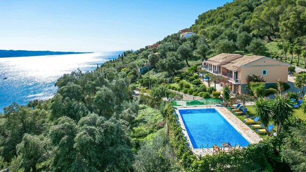 Villa collinare con piscina, immersa nel verde e affacciata su un corpo d'acqua.