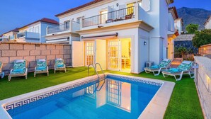 A two-story house with a swimming pool, a balcony, and a stone wall. - Villa Costa Adeje by Villa Plus (Adeje)