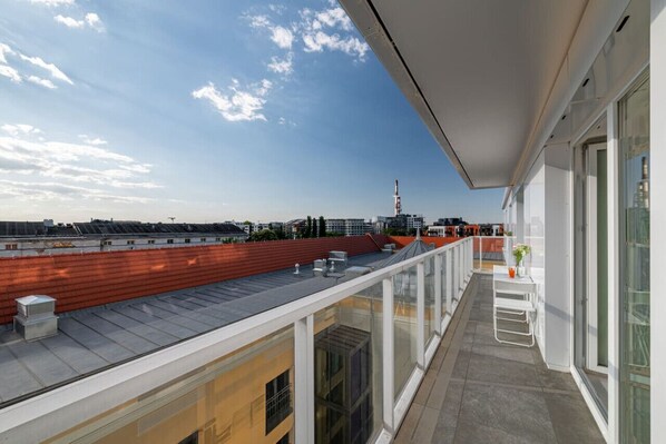 A modern building with a rooftop terrace, large windows, and a view of the city skyline. - Witolda Riverside Apartments - Balcony, City View - by Rentujemy (Wroclaw)
