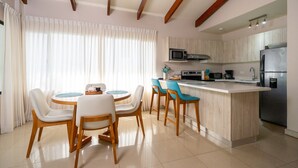 A modern kitchen with a central island, wooden chairs, and a dining table. - Villas Sol 21 Serenity Place at Playa Hermosa (Playa Hermosa)