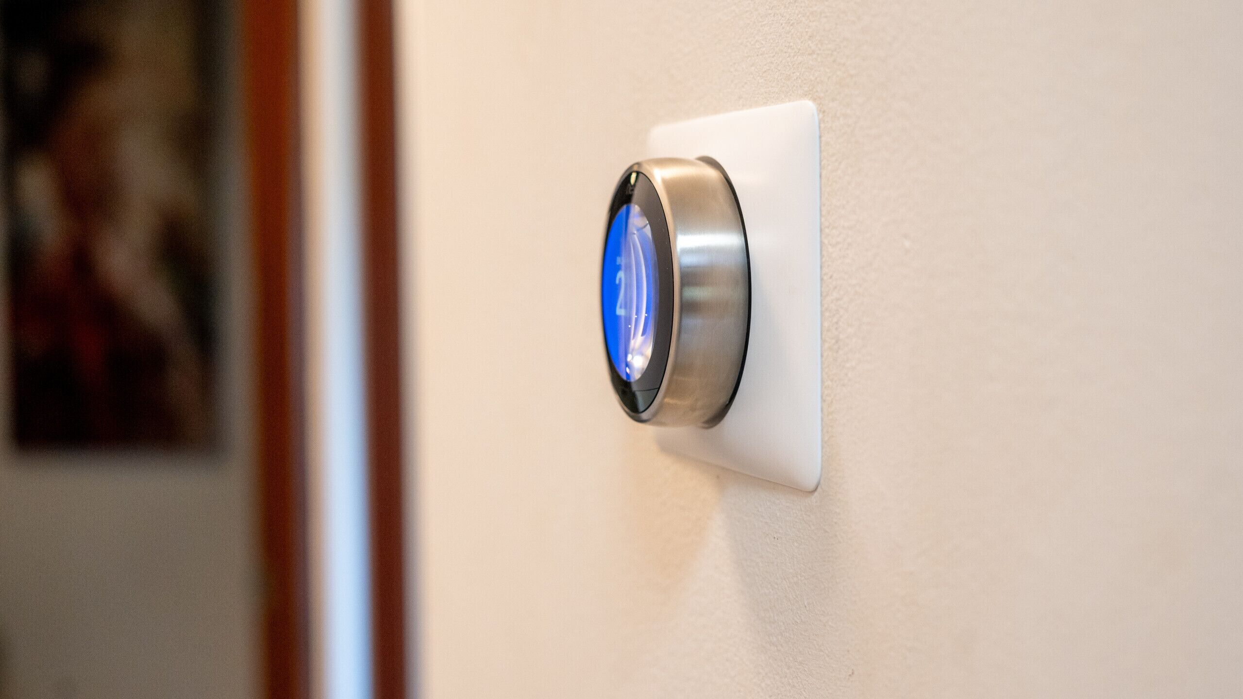 A wall-mounted thermostat with a digital display.