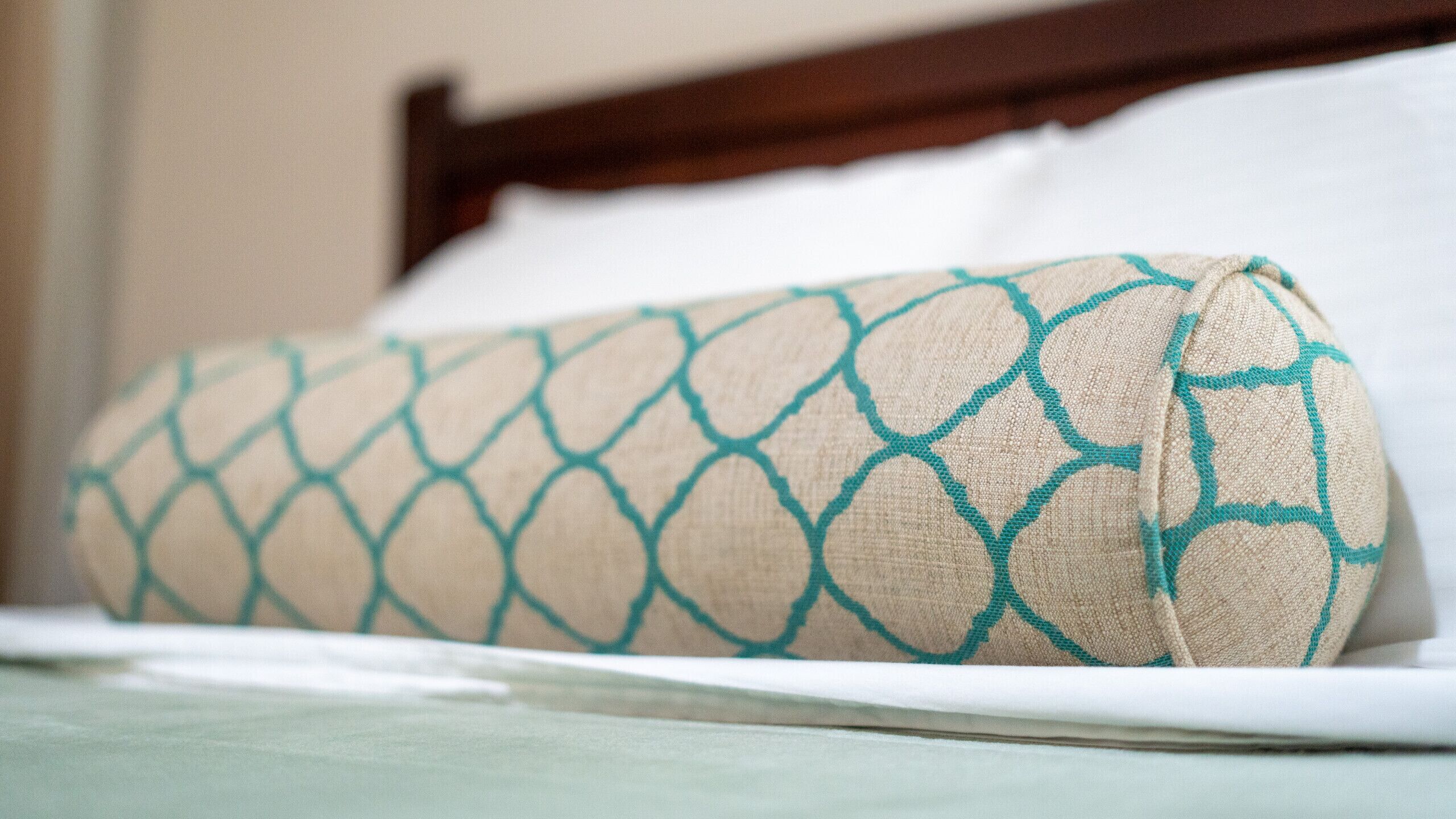 Un lit avec un oreiller à motifs et une tête de lit en bois.