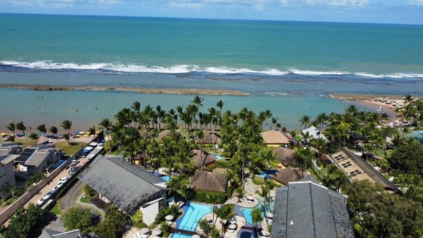 A resort with a swimming pool, beach access, and palm trees. - Condomínio Nannai Residence (Ipojuca)
