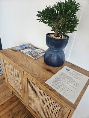 Welcome to a cozy retreat, where a potted plant and a small tree bring life to a stylish console table.