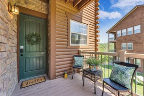 A wooden cabin with a green door, a balcony with chairs, and a small welcome mat. - Walk to Table Rock Lake/SDC Fireworks View! (Branson)