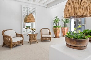 Relax in this serene space with a wicker sofa, armchair, and potted plants.