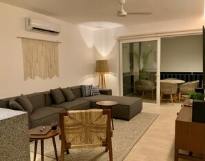 Relax in this stylish living space with a sofa, table, and chair, offering a view of the outdoors.