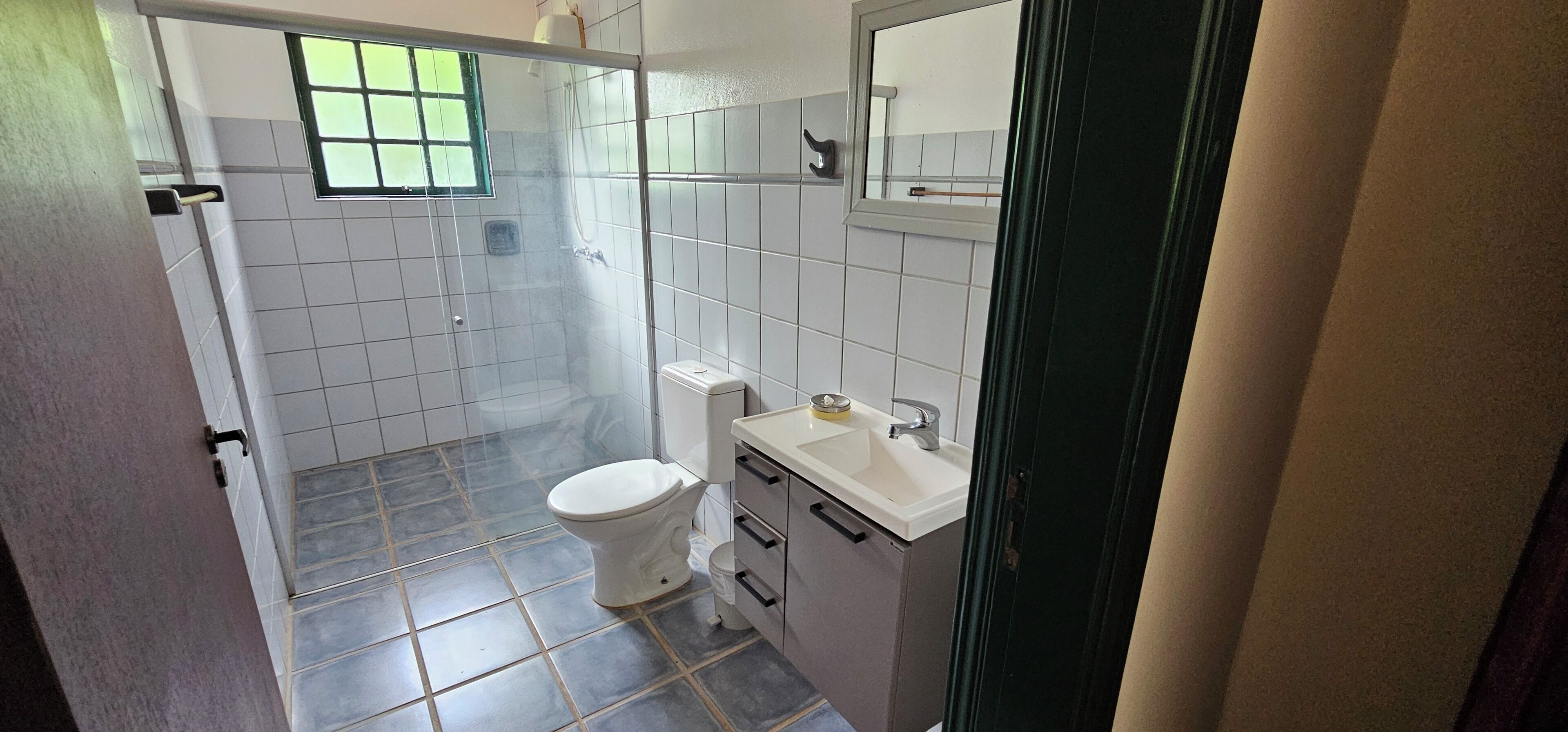A bathroom with a toilet, sink, and shower.