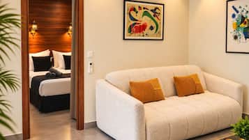 Una habitación de hotel con una cama, un sofá y dos cuadros en la pared.