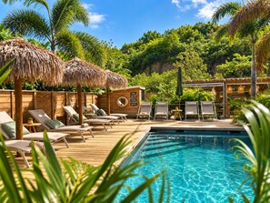 A poolside area with lounge chairs, a wooden deck, and a thatched-roof structure. - The Forest Suites at Anse Marcel | Boutique Hotel & Restaurant (Anse Marcel)