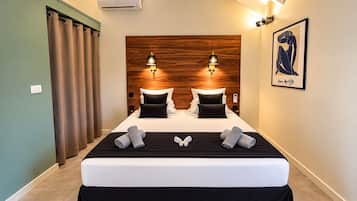 A double bed with a wooden headboard, two bedside lamps, and a framed artwork on the wall.