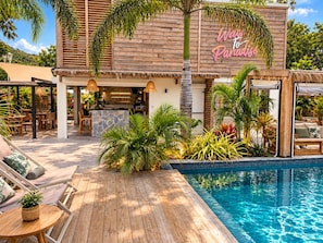 Un complexe hôtelier doté d’une piscine, d’un espace extérieur aménagé et d’un bar.