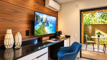 A modern kitchen with a flat-screen TV, wooden cabinetry, and a blue chair.