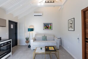 Una sala de estar moderna con un sofá, una mesa de centro, una lámpara y obras de arte en las paredes.