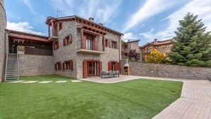 A stone building with a balcony and a well-maintained lawn. - House 4 rooms 10 Pax, Fireplace, BBQ & Cadí Views (Montellà)