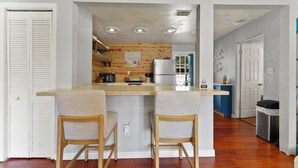A compact kitchen with wooden cabinets, a central island, and two bar stools. - 10 min Lido Key Beach~St. Armand Circle~ Short drive to Siesta Key Beach (Sarasota)