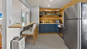 A compact kitchen with a refrigerator, microwave, and wooden shelves. - 10 min Lido Key Beach~St. Armand Circle~ Short drive to Siesta Key Beach (Sarasota)
