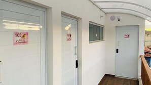 A corridor with three doors, each marked with a number and a bird illustration. - SAO FRANCISCO FLATS - GUAPE MG (Guape)