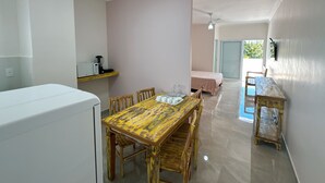 A compact living space with a dining area, kitchenette, and a bedroom with a view. - SAO FRANCISCO FLATS - GUAPE MG (Guape)