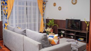 A living room with a sofa, TV, and decorative items. - Golden Homes  (Nairobi)