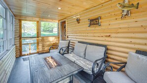 A log cabin interior with a sofa, chairs, a fire pit, and a mounted fish. - Lakefront Cabin w/ Dock, Fire Pits in Danbury! (Danbury)
