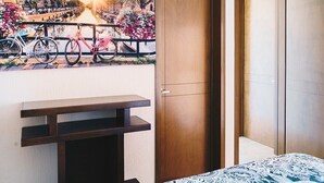 A hotel room with a bed, a wooden wardrobe, and a view of a canal with bicycles and flowers. - Torre San Francisco Zoológico 132 (Guadalajara)