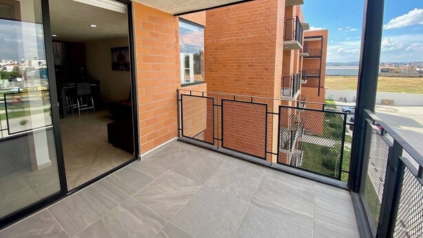A balcony with a view of a brick building and a clear sky. - Torre San Francisco Zoológico 132 (Guadalajara)