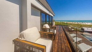 A balcony with outdoor seating and a view of the beach. - Shangri-La | Bean Point | Rooftop Pool | Golf Cart (Anna Maria)