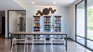 A modern kitchen with a central island, a refrigerator, and a vending machine. - ECHO Suites Extended Stay by Wyndham Spartanburg (Spartanburg)