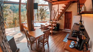 A wooden interior with a dining area, kitchen, and a staircase leading to an upper level. - Casa da Mata (Sao Bento do Sul)