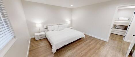 A bedroom with a large bed, bedside tables, and a built-in wardrobe.