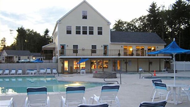A hotel with a swimming pool, lounge chairs, and a covered patio area. - Charming Cottage for Rent at Beach Dreams Cottages, Wells, Maine! Unit #229 (Wells)