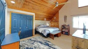 A bedroom with a wooden ceiling, a bed, a desk, and a window. - Kansas Lake House With Private Boat Dock (Anthony)