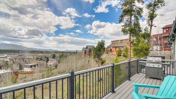 A deck with a grill and a turquoise chair, overlooking a residential area with houses and mountains. - 6 Mi to Skiing: Mtn-View Fraser Duplex (Fraser)