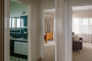 Un pasillo que conduce a un comedor con una silla de madera y un sofá.