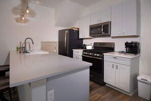A modern kitchen with a central island, stainless steel appliances, and white cabinetry. - Horseshoe Haven, Immaculate 2BD/2BA, Pet friendly! (Mt. Crested Butte)