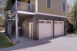 A two-story building with a balcony, a garage, and a door. - Horseshoe Haven, Immaculate 2BD/2BA, Pet friendly! (Mt. Crested Butte)