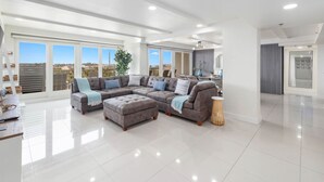 Amplia sala de estar con un sofá modular grande, una mesa de centro y una mesita auxiliar.