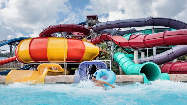 Een waterpark met meerdere glijbanen in verschillende kleuren.