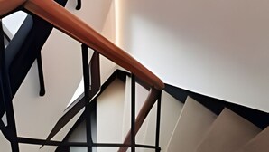 En elegant, moderne trappe med spiralformet design, der kombinerer metal og træ.