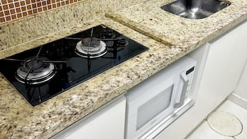 Microondas, parrilla de estufa, utensilios de cocina y congelador