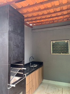 Una cocina compacta con una parrilla integrada, un lavamanos y una ventana pequeña.