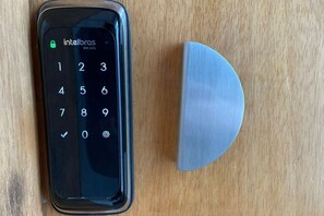 En smartphone med numerisk tastatur og låseskærm, placeret på en træoverflade.